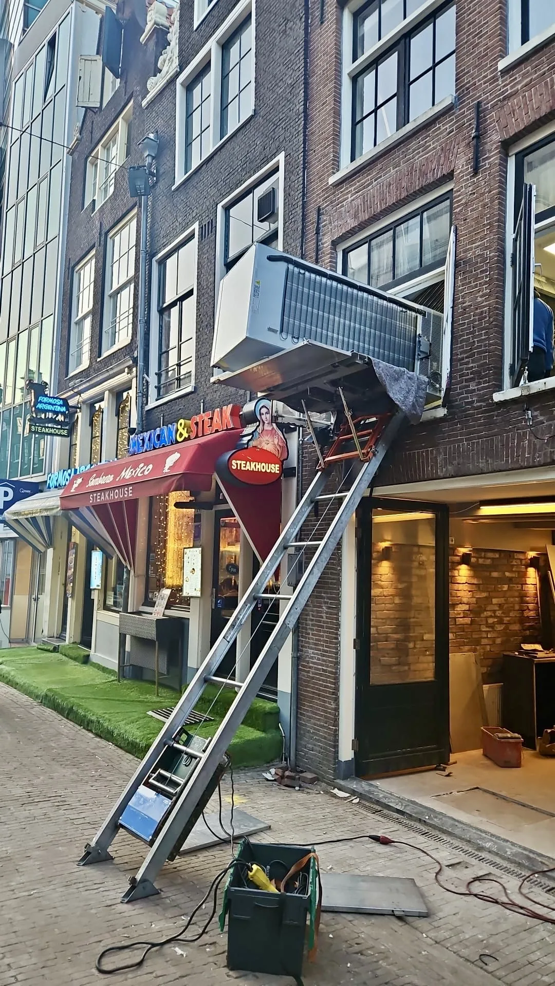 Opbouwlift opgesteld in een smalle steeg in het centrum van Amsterdam