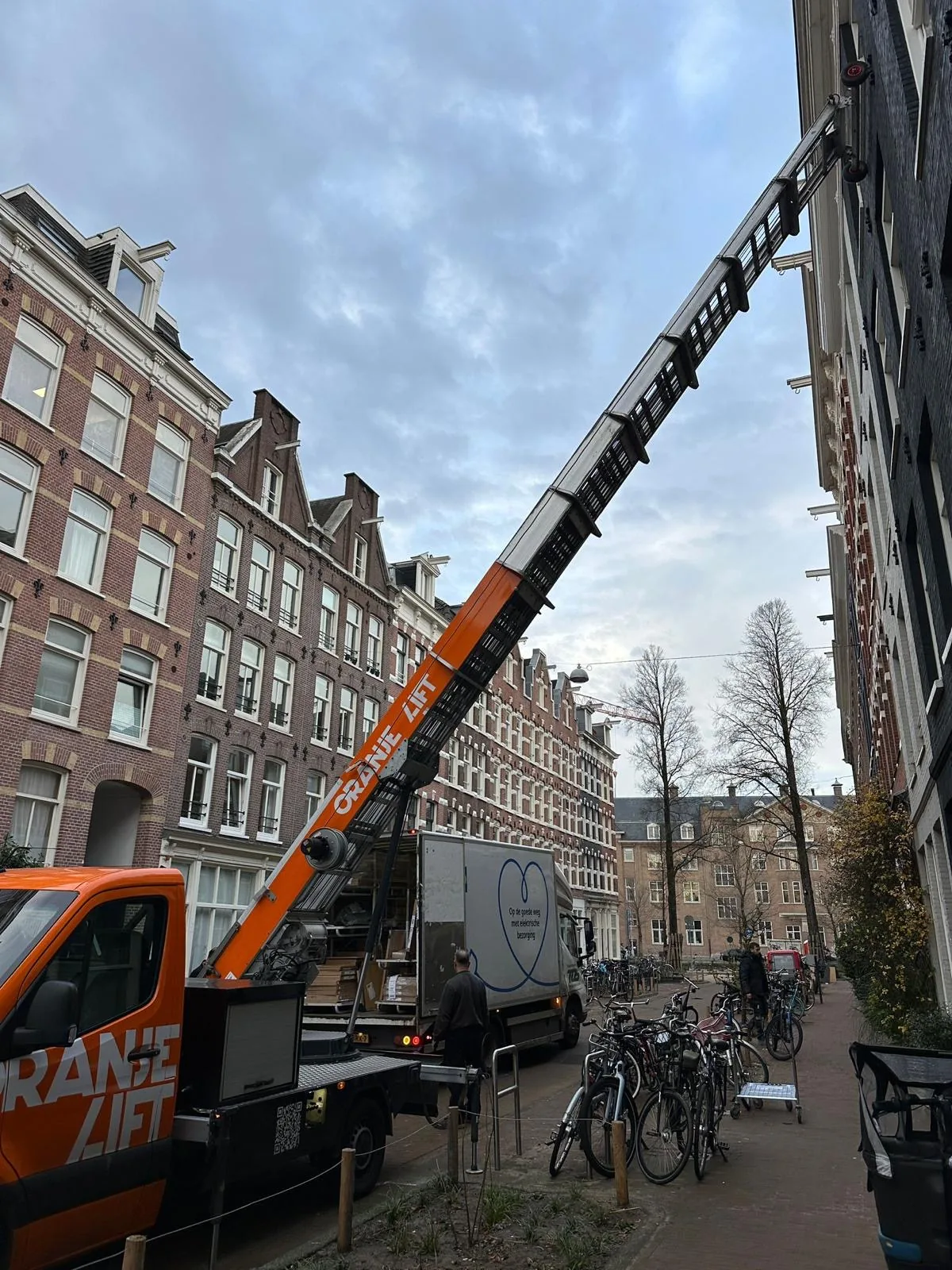 Verhuislift opgesteld aan een Amsterdams grachtenpand met uitgeschoven ladder
