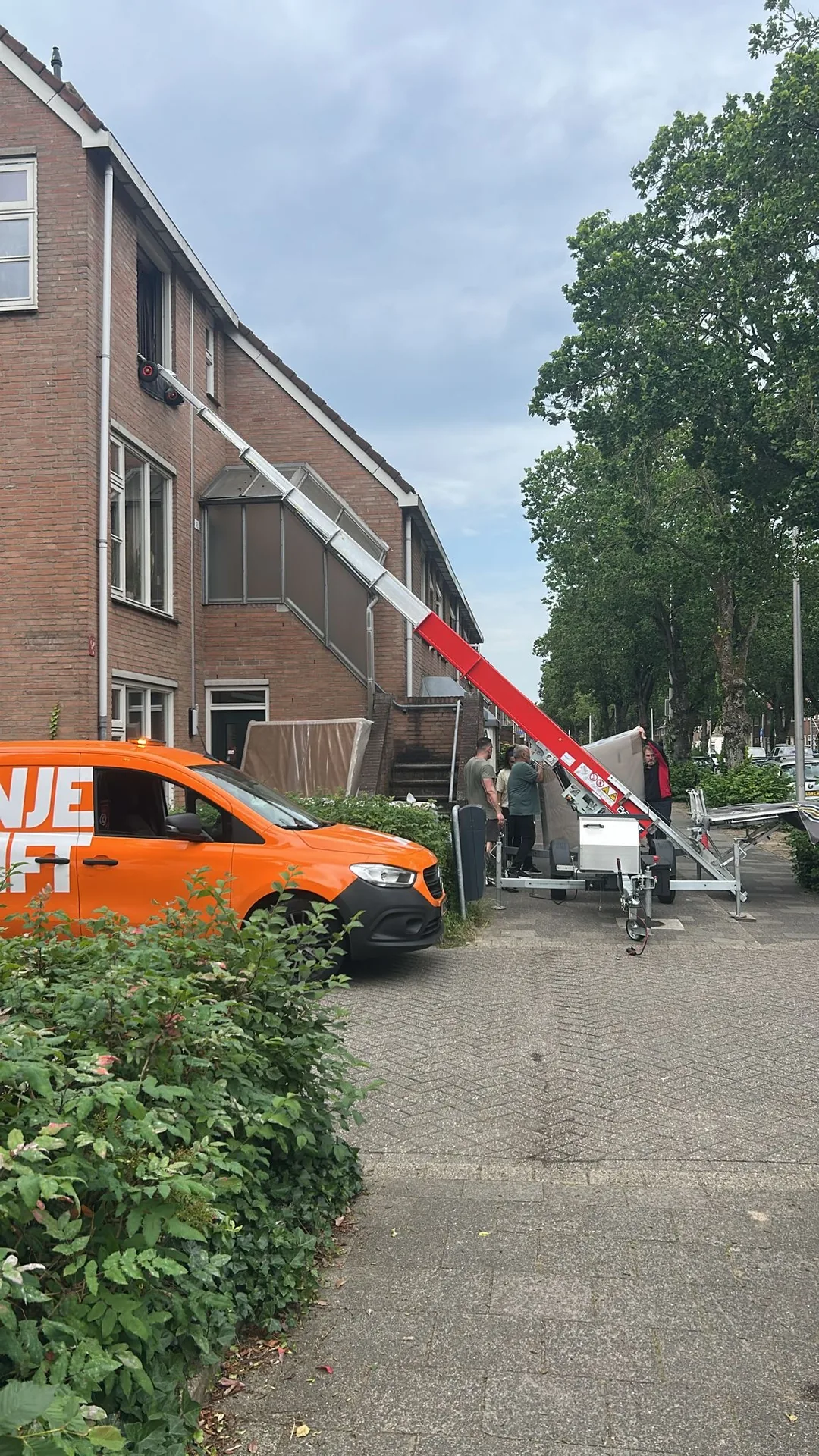 Verhuislift en verhuiswagen in een woonwijk