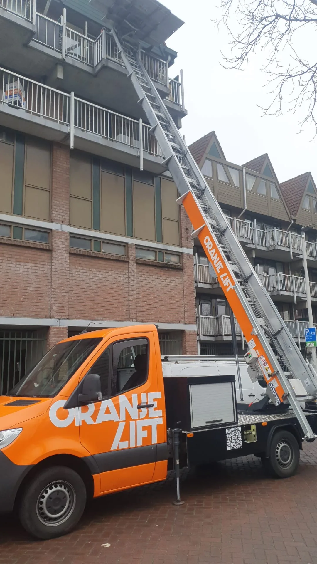 OranjeLift verhuislift met ladderlift bij flatgebouw met balkons