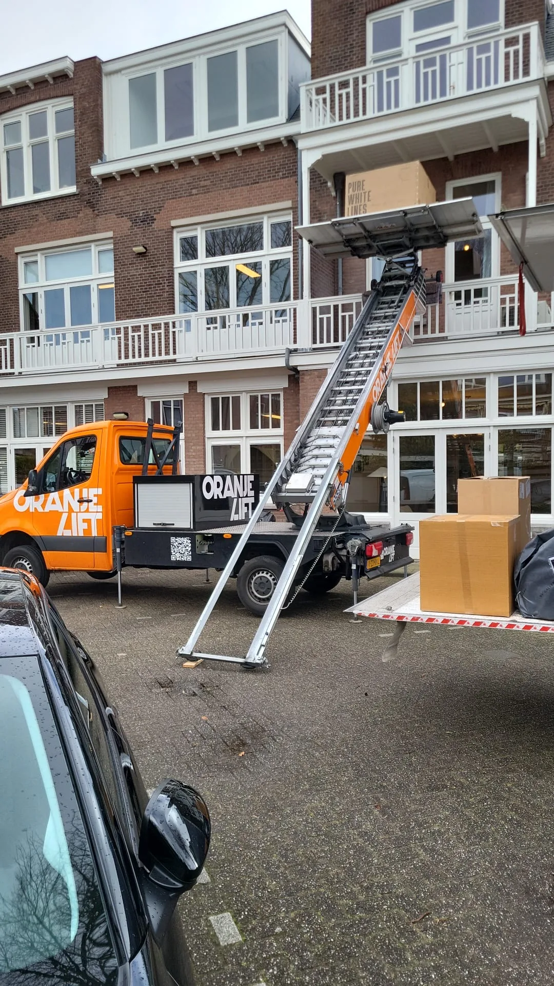 Verhuisdozen worden geladen via de meubellift bij een appartement