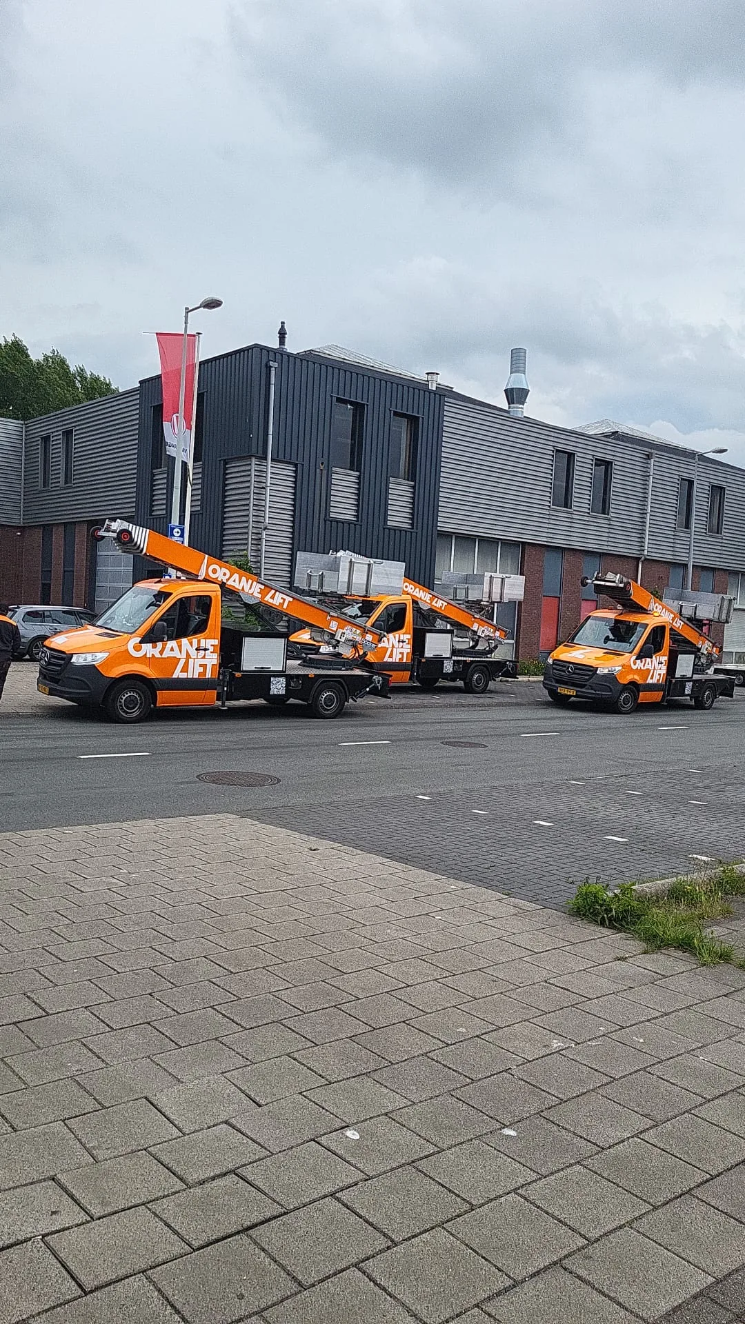 Vloot van drie OranjeLift ladderliften op een rij, klaar voor inzet door heel Nederland